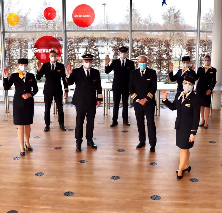 a group of people wearing face masks and standing in a room