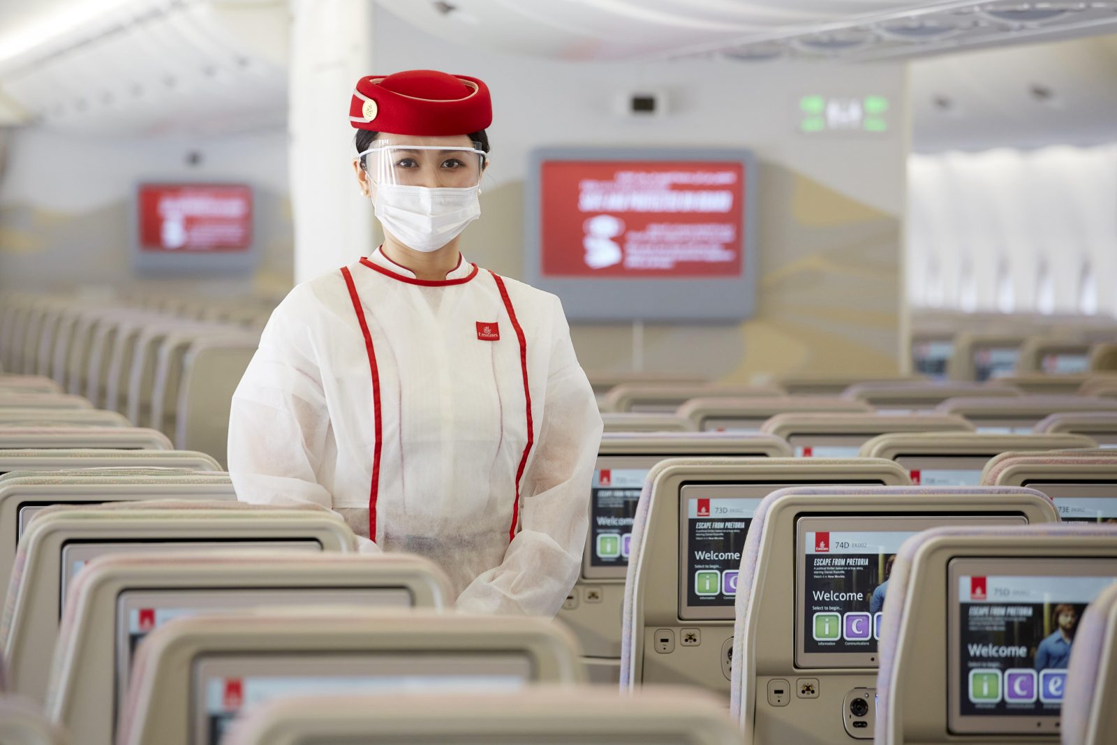 a woman in a white uniform and mask standing in rows of seats