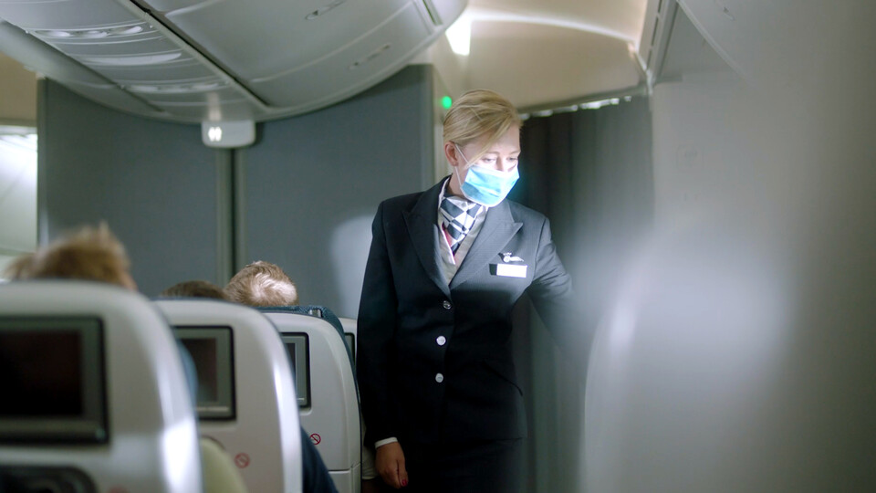 a woman wearing a mask on a plane