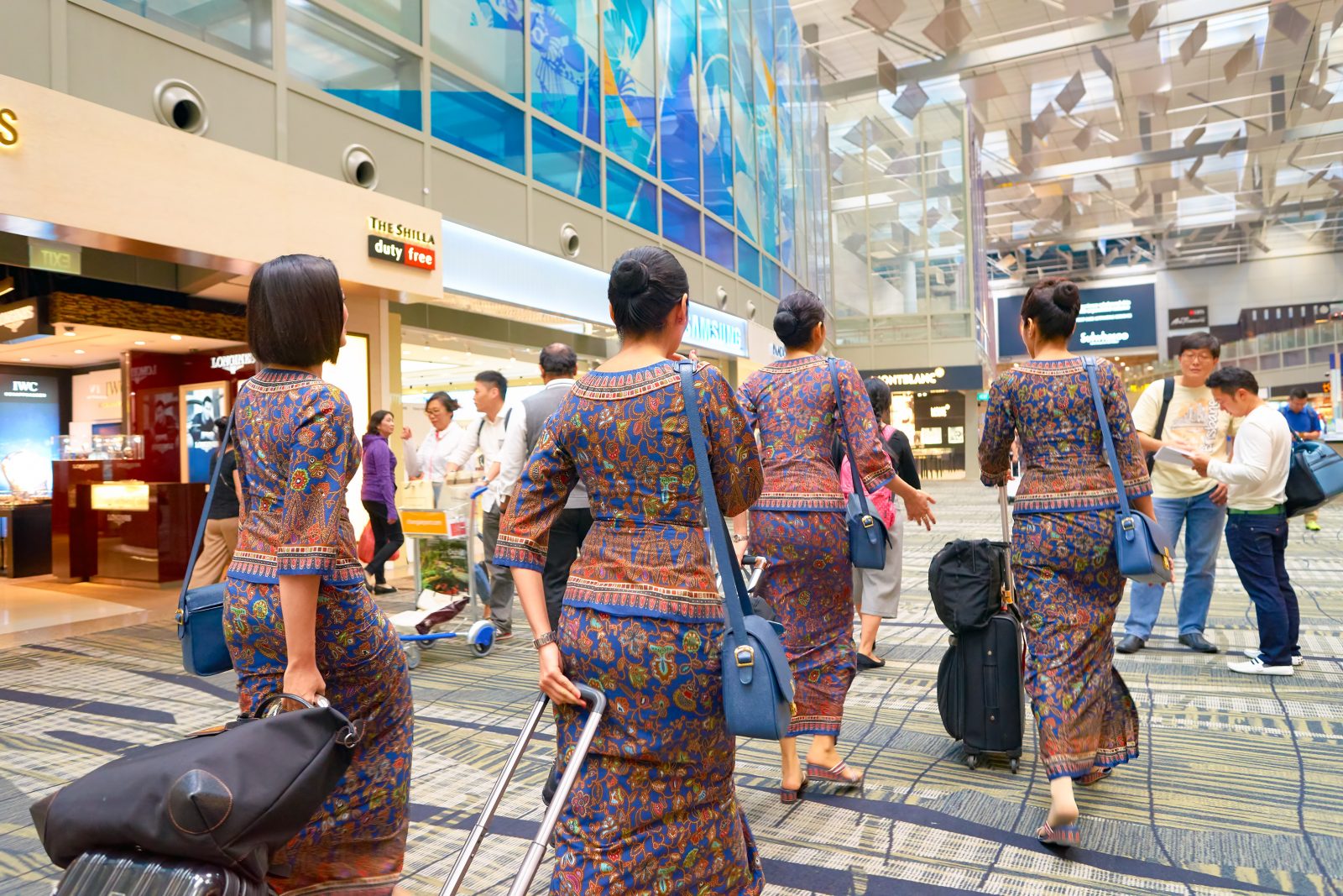 a group of women in colorful dresses with luggage