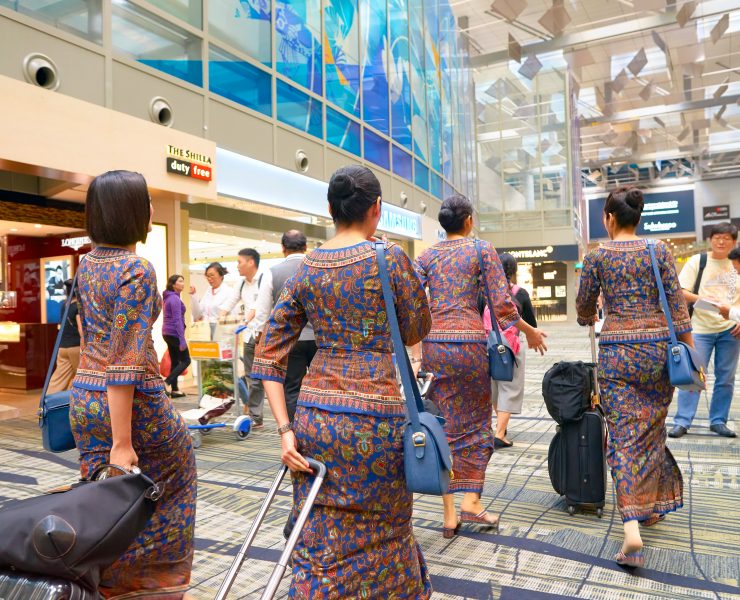 a group of women in colorful dresses with luggage