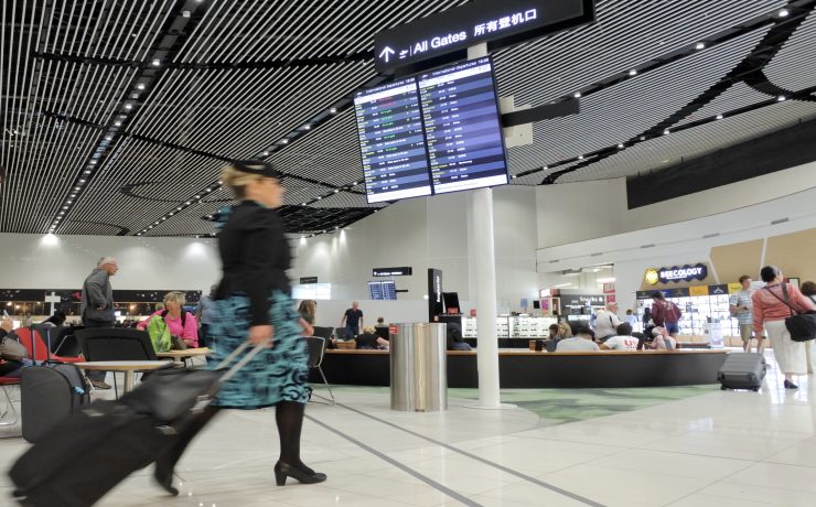 a woman walking with luggage in an airport
