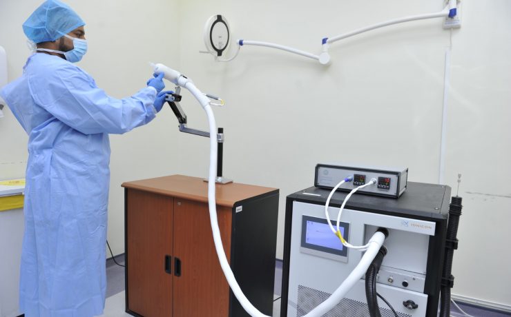 a person in a blue uniform and mask holding a machine