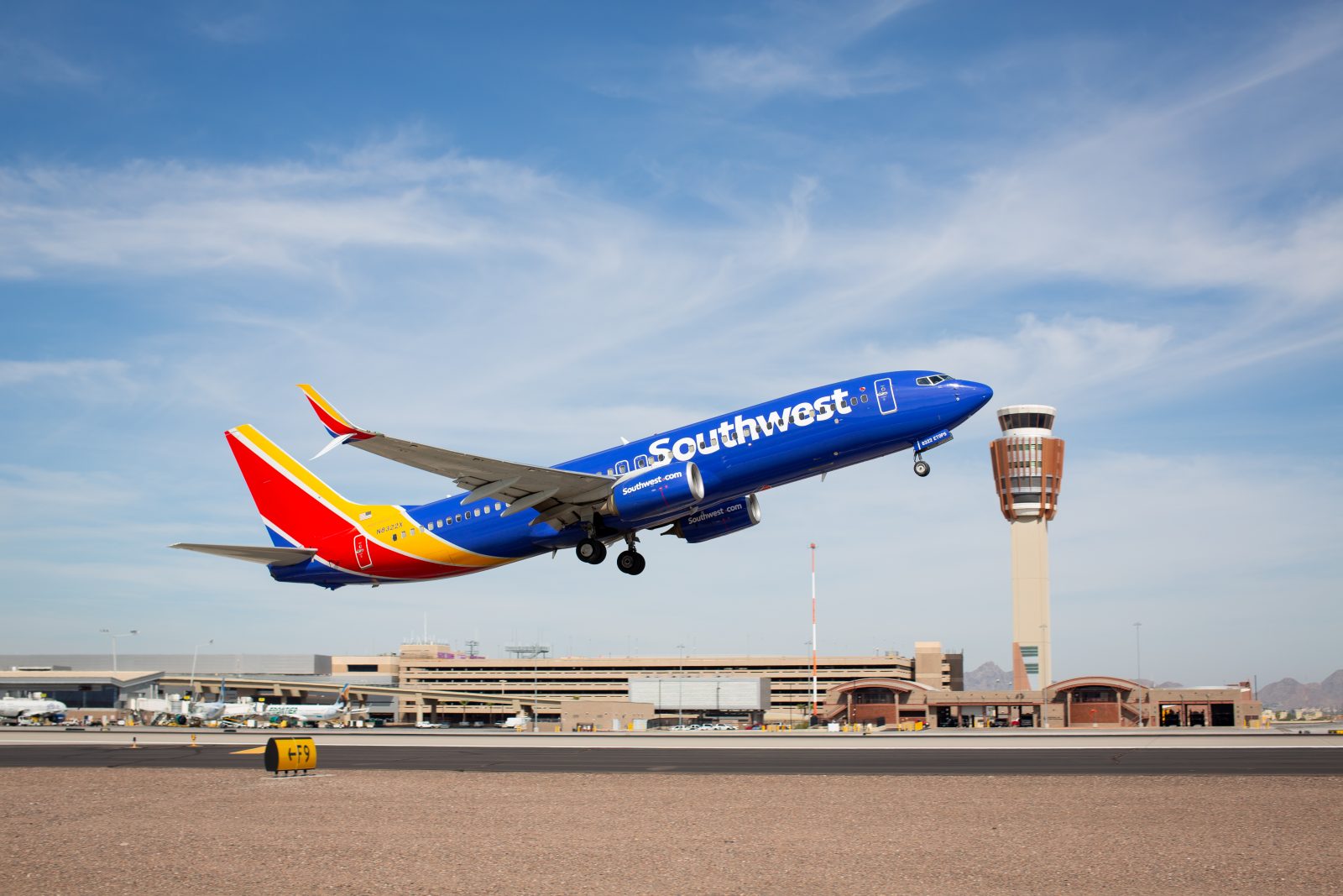 a blue and yellow airplane taking off