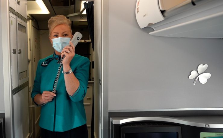 a woman wearing a mask and holding a phone in a room