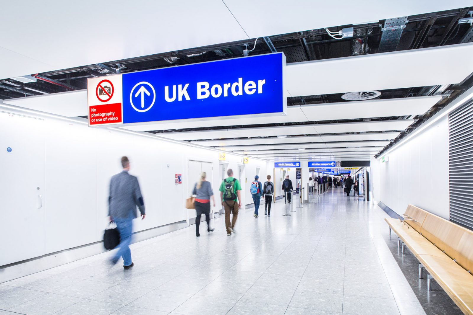people walking in a hallway with a sign