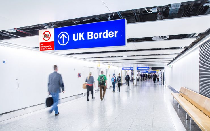 people walking in a hallway with a sign