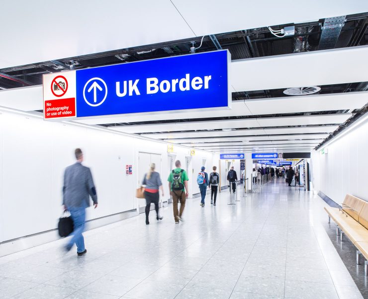 people walking in a hallway with a sign