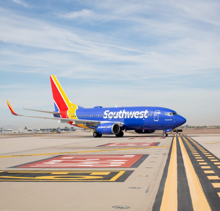 a blue airplane on a runway