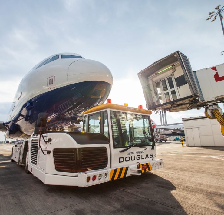 a white vehicle with a large airplane on the back