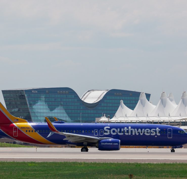 a blue and red airplane on a runway