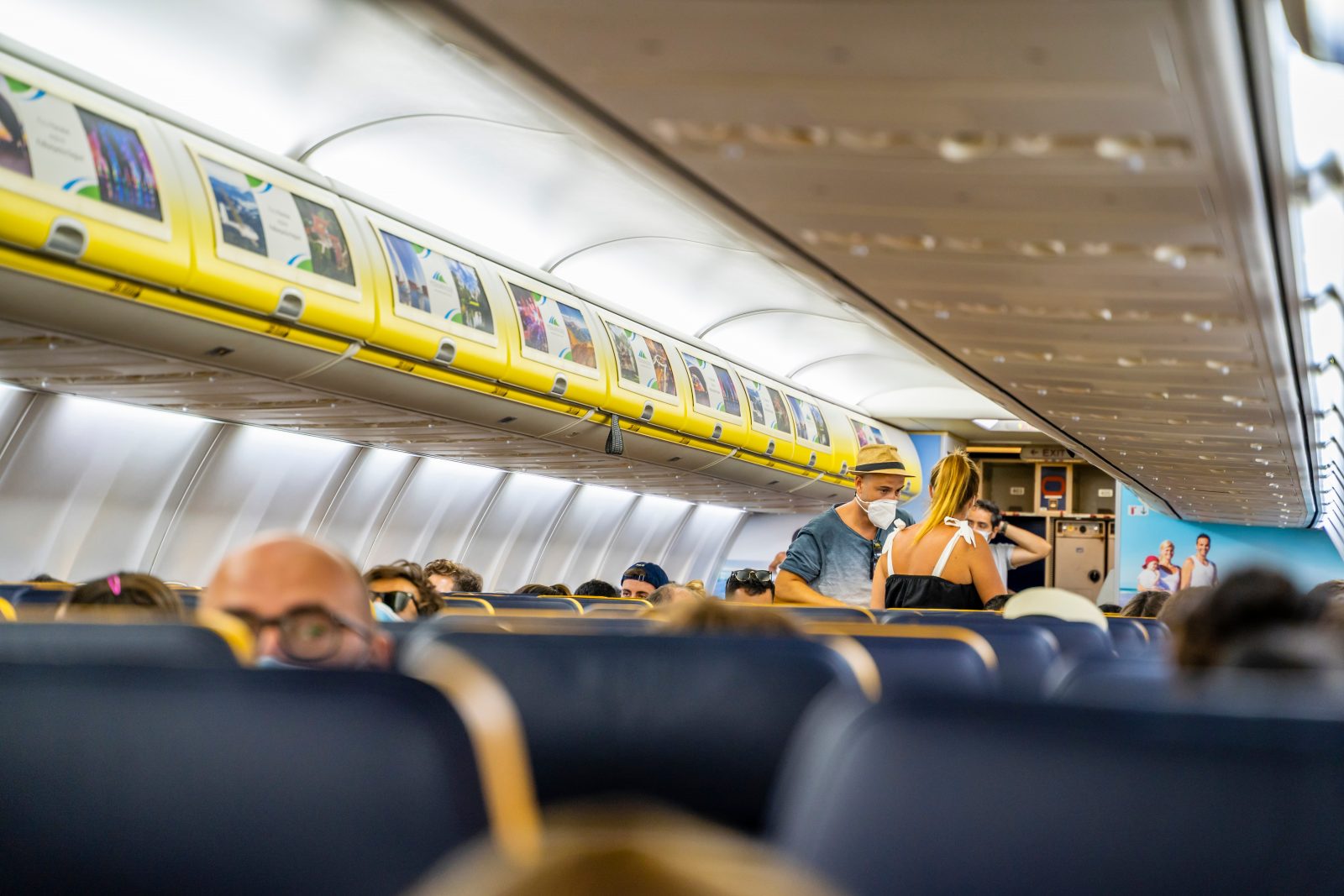 people in an airplane with people wearing masks