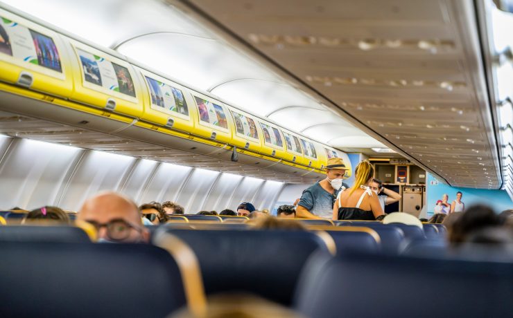 people in an airplane with people wearing masks