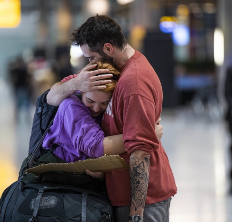 a man and woman hugging in an airport