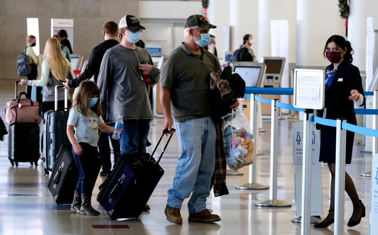 people with face masks and luggage in an airport