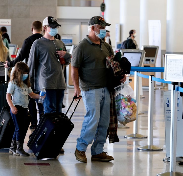 people with face masks and luggage in an airport