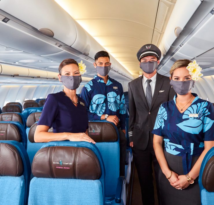 a group of people wearing face masks on an airplane