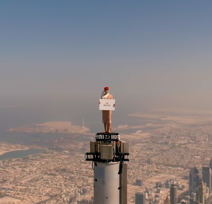 a man standing on a tower holding a sign
