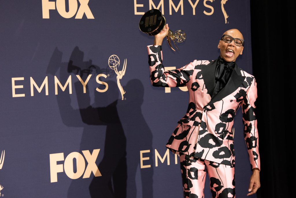 a man in a pink suit holding a trophy