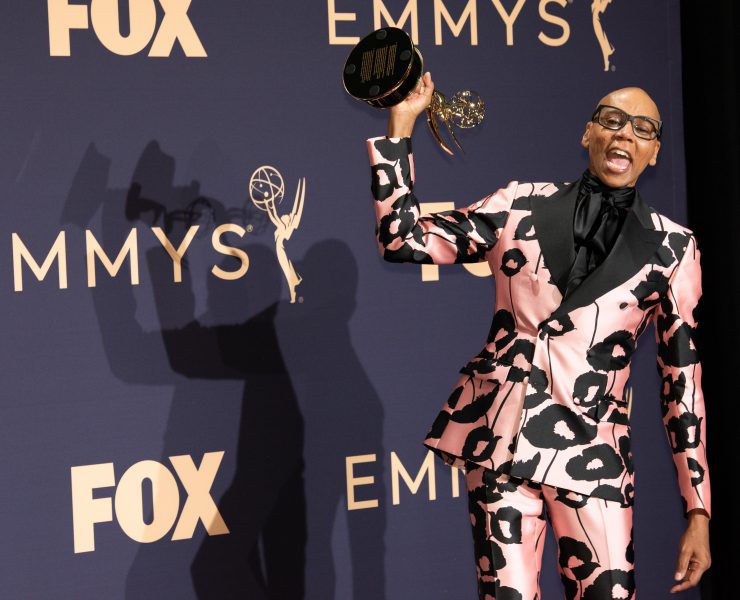 a man in a pink suit holding up a trophy