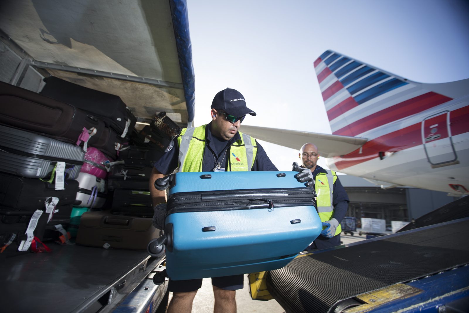 a group of men loading luggage into an airplane