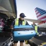 a group of men loading luggage into an airplane