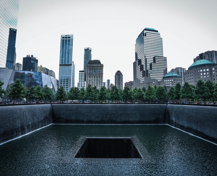 a large square pool with trees in the background