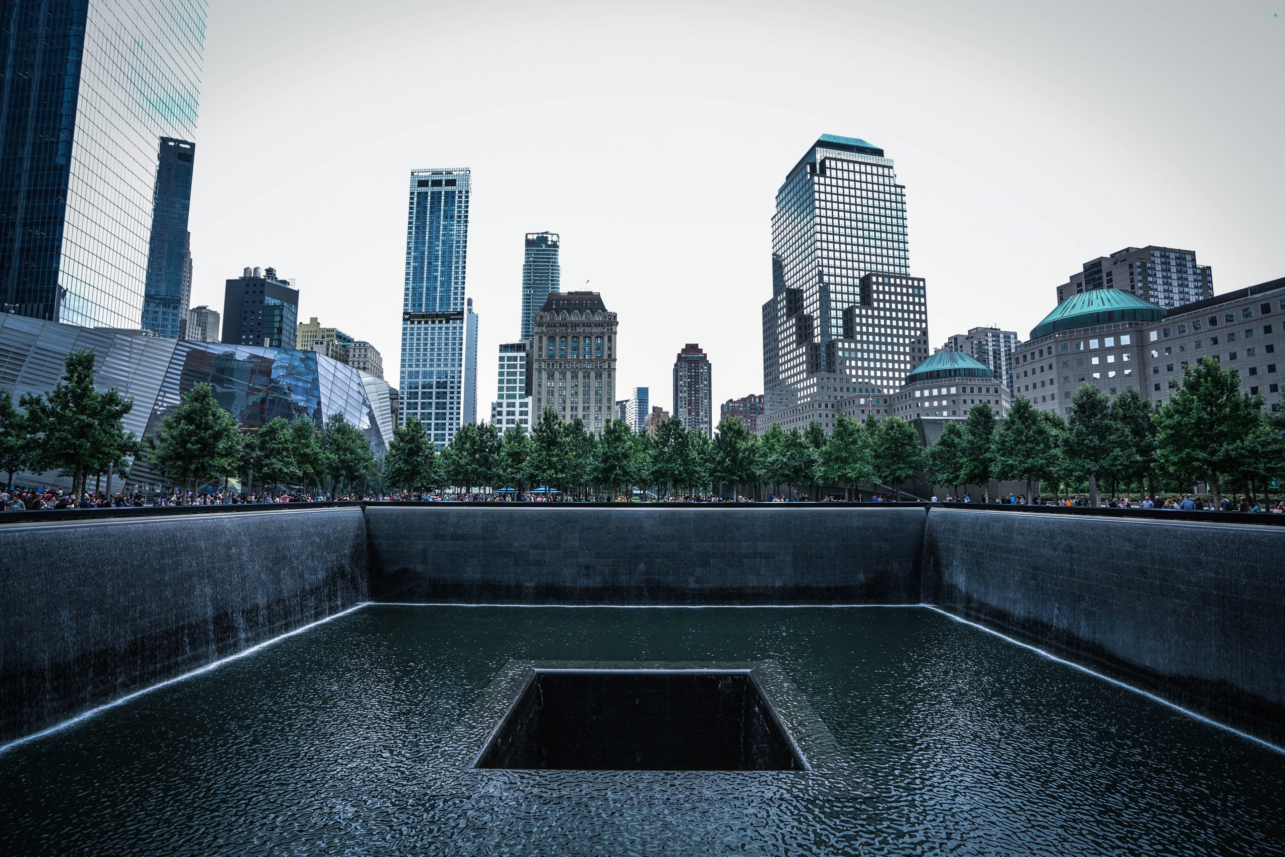 a large square pool with trees in the background
