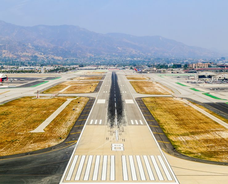an airport runway with a mountain in the background