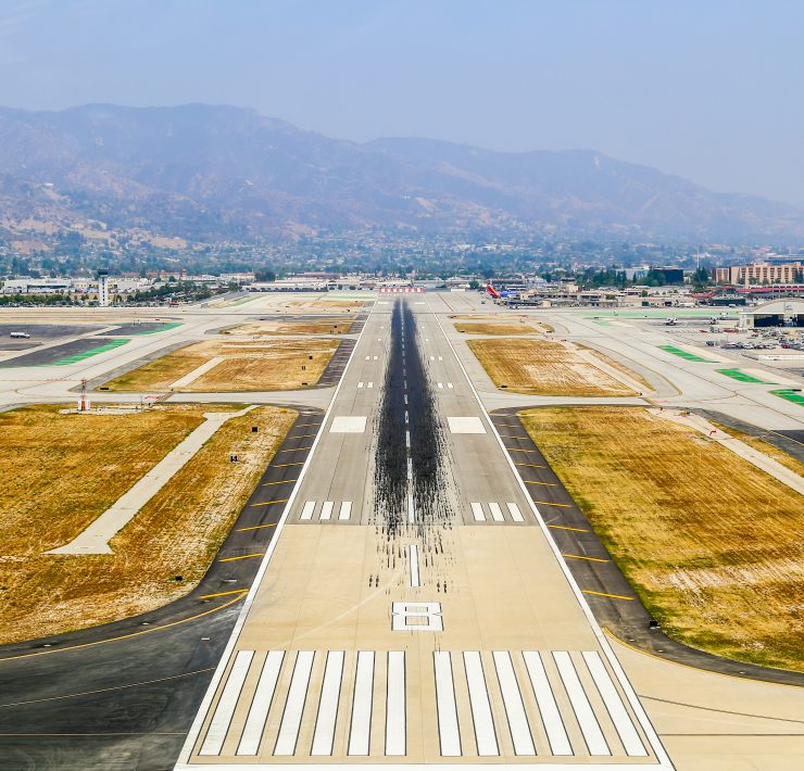 an airport runway with a mountain in the background