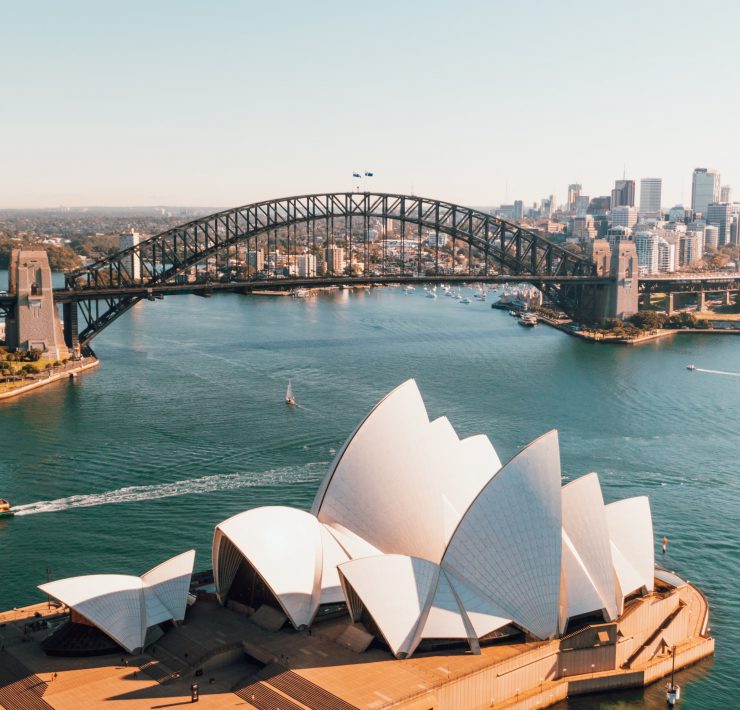 Sydney Harbour Bridge over water with a large building and a city