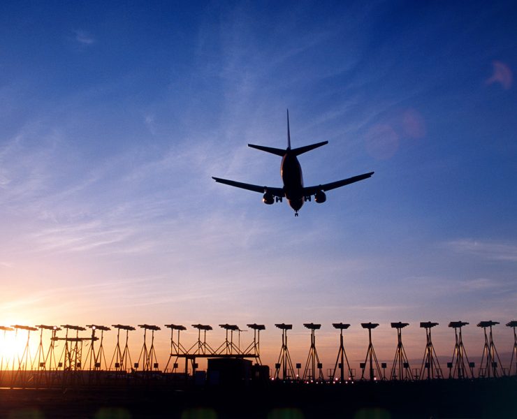 an airplane flying over a runway