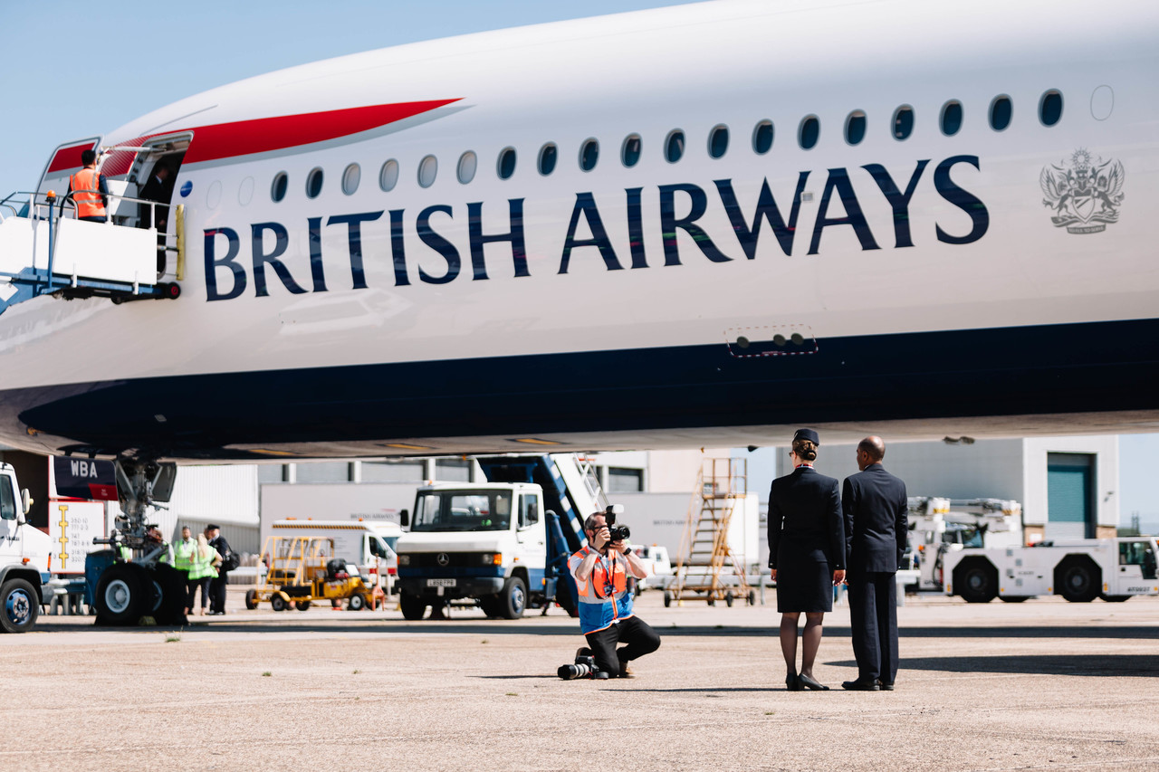 a group of people standing next to a plane