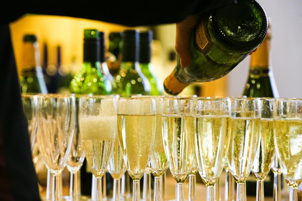 a person pouring champagne into glasses