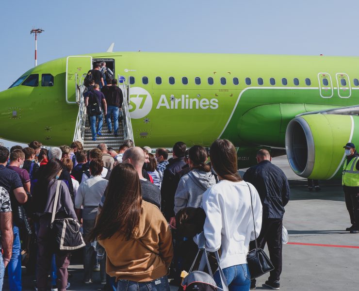 a group of people standing in front of a green airplane