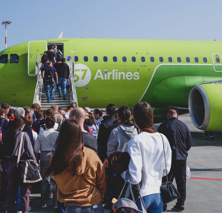 a group of people standing in front of a green airplane