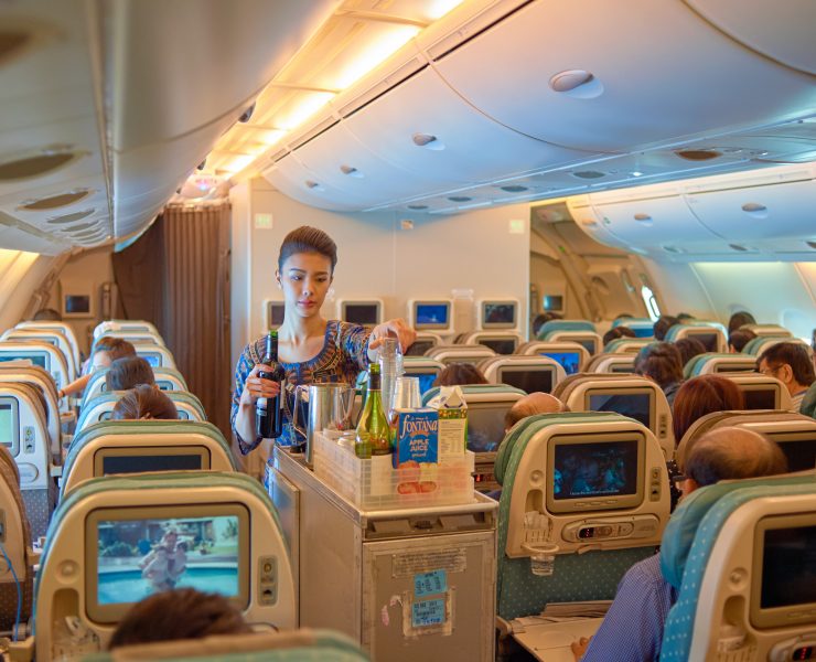 a woman serving drinks in an airplane