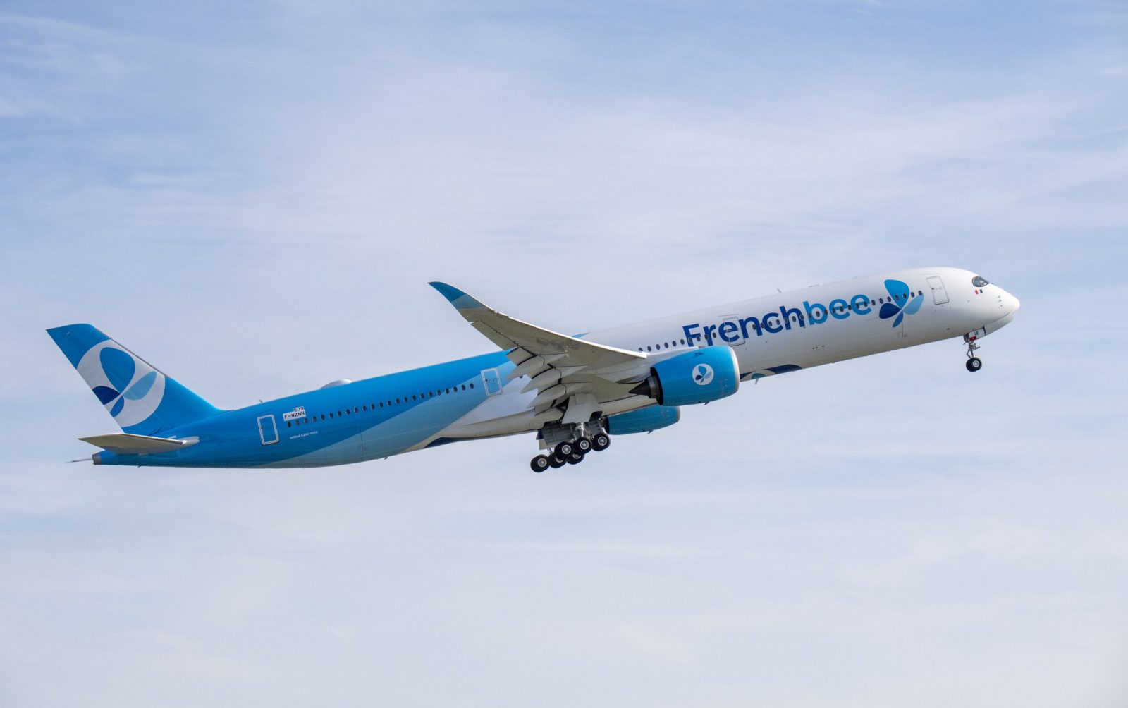 a blue and white airplane flying in the sky