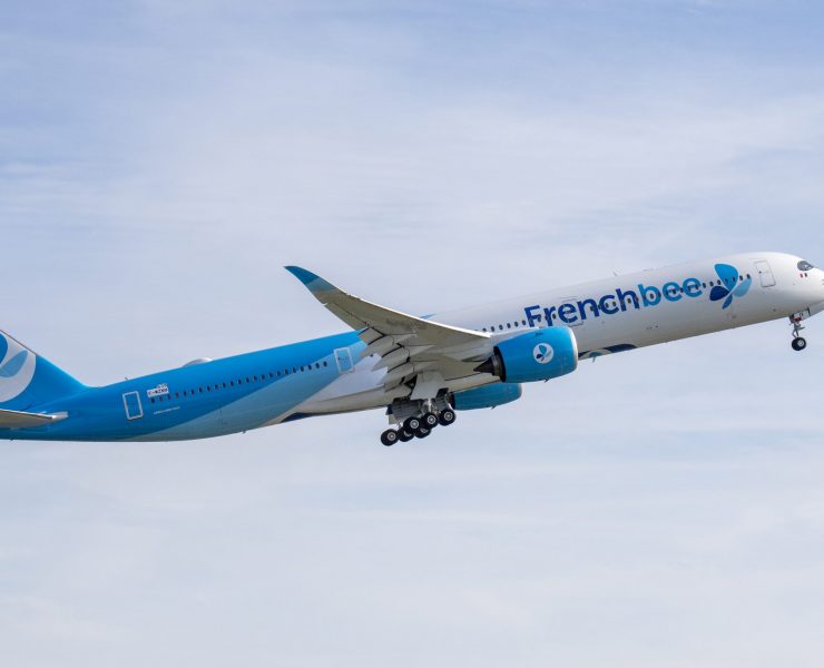 a blue and white airplane flying in the sky