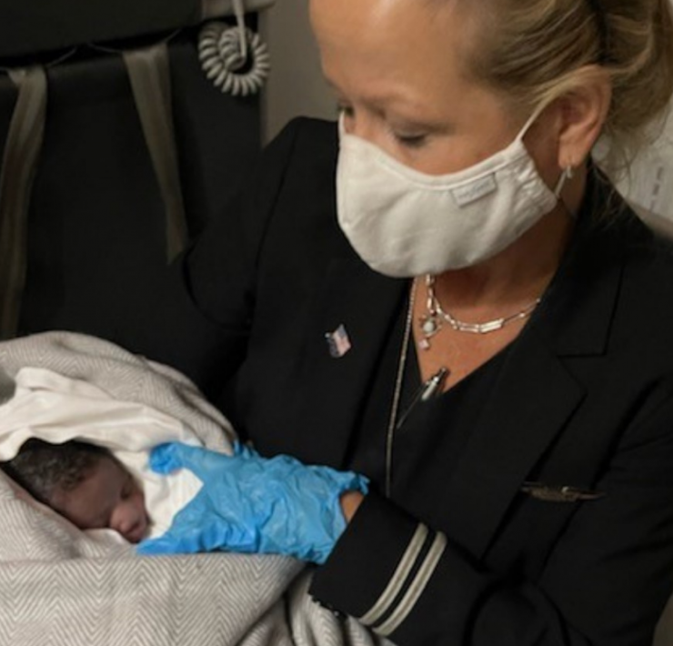 a woman wearing a mask and holding a baby