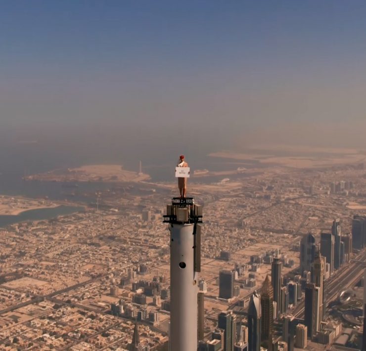 a person standing on a tall tower with a sign on top