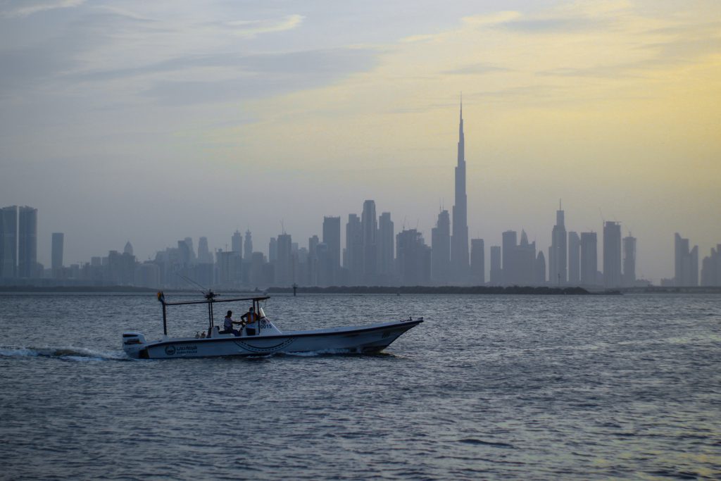 a boat on the water with a city in the background