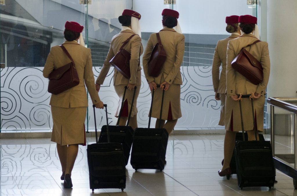 a group of women in uniform with luggage