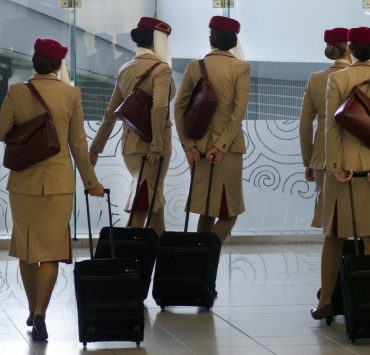 a group of women in uniform with luggage