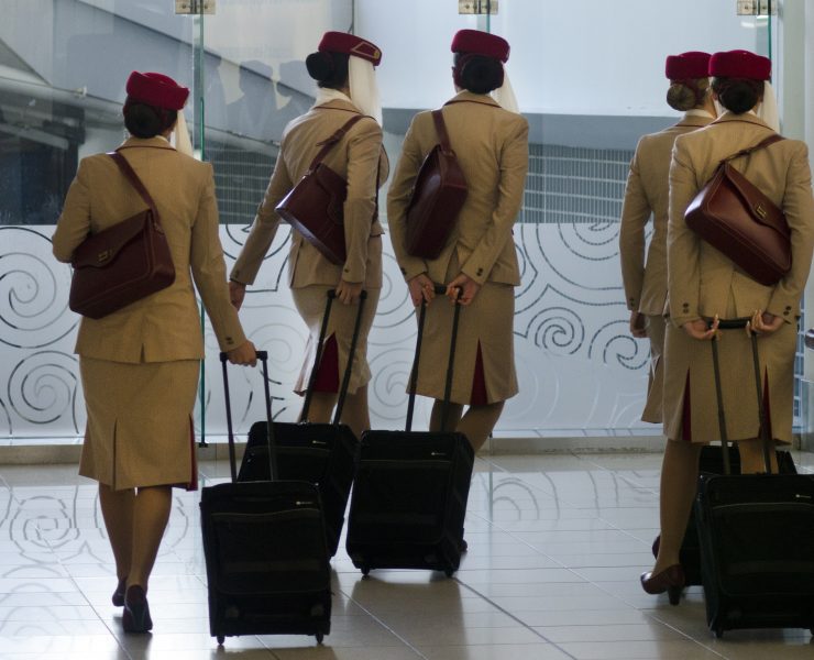 a group of women in uniform with luggage