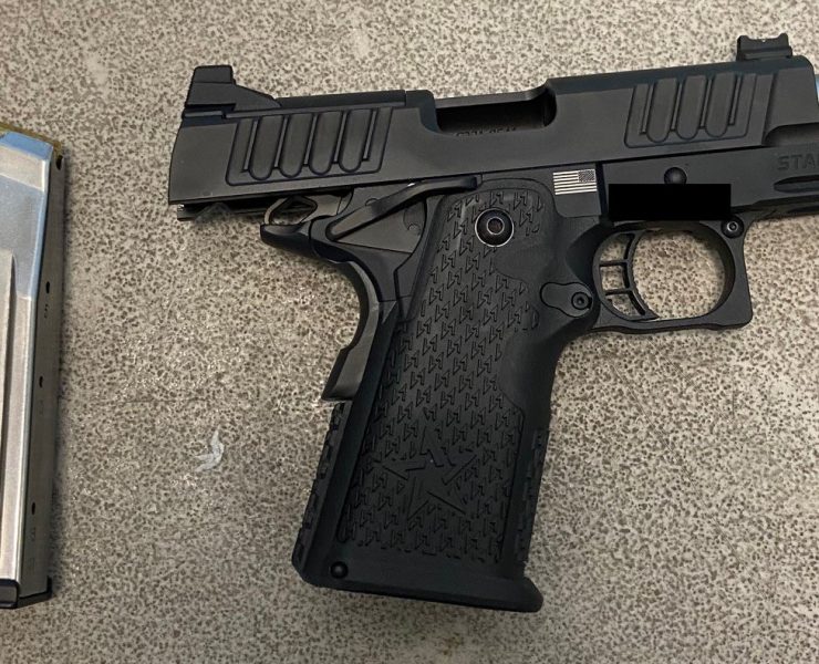 a black gun on a grey surface