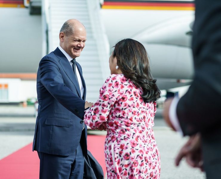 a man in a suit shaking hands with a woman