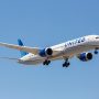 a white airplane with blue text on it