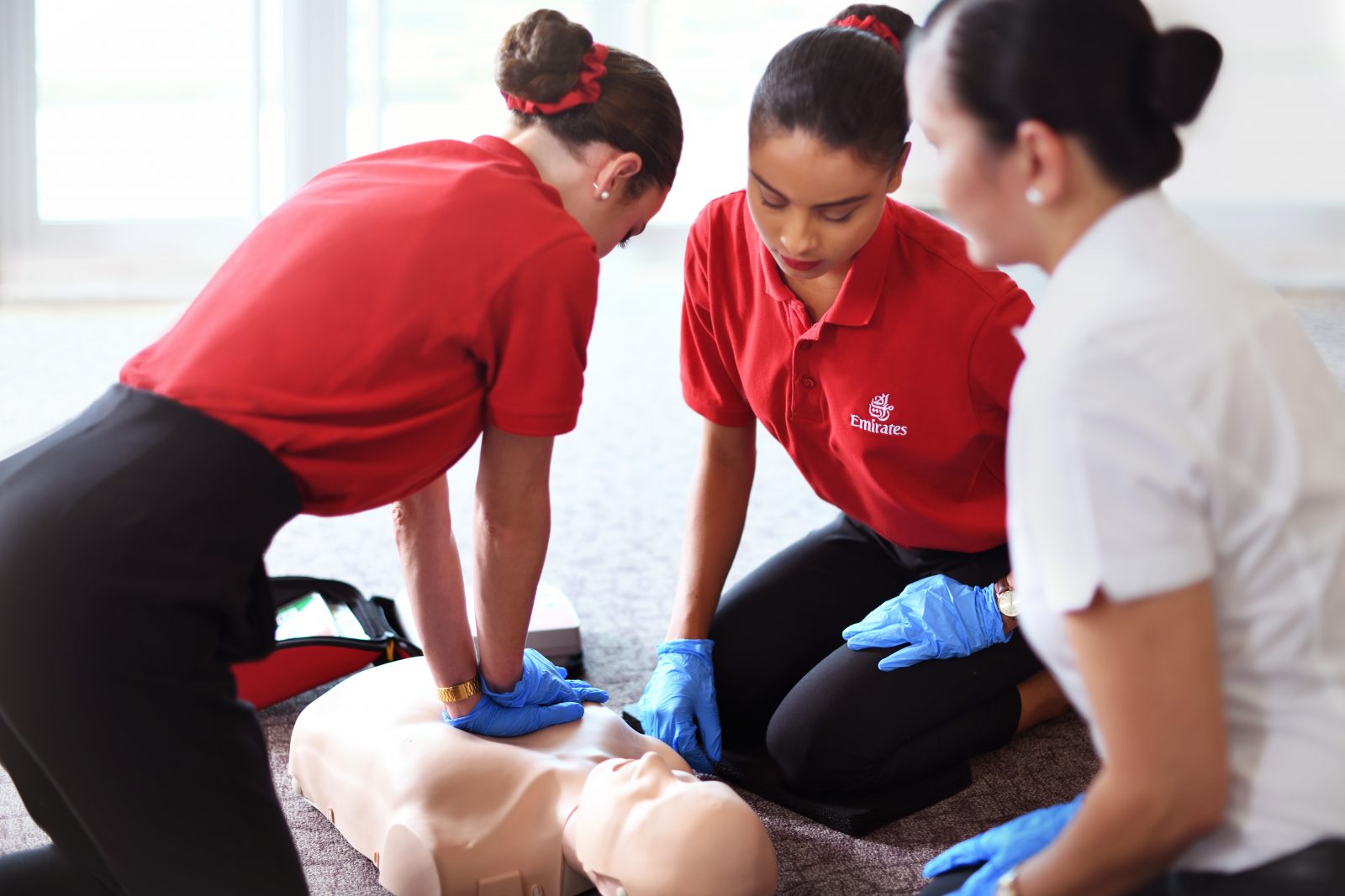 a group of women practicing cpr on a mannequin