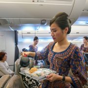 a woman pouring tea into a tray on an airplane